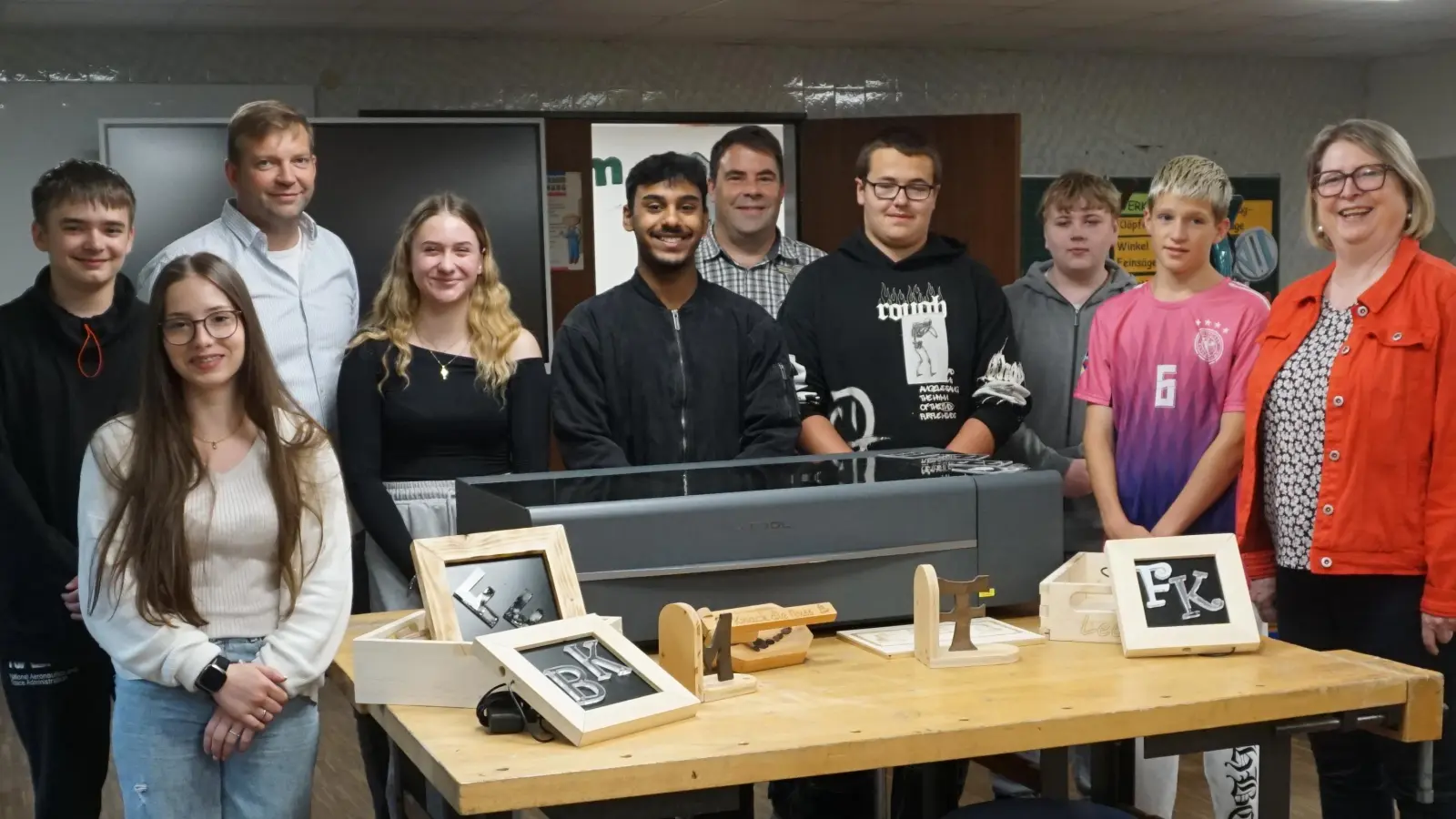 Leo Fütterer (hinten, Zweiter von links), Andreas Kempf (Fünfter von links), Rektorin Gisela Kastner (rechts) und Schülerinnen und Schüler der 7. bis 9. Klassen freuen sich über den neu angeschafften Lasercutter.  (Bild: Mittelschule Mitterteich/exb)