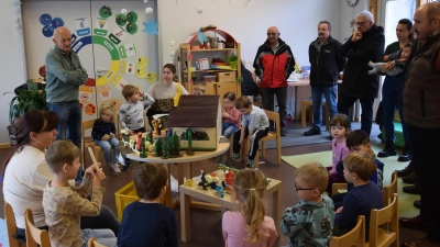 Stellvertretend für die gesamte Einrichtung nahmen die Kinder und die Mitarbeiterinnen der Gelben Gruppe das großzügige Geschenk der „OWV-Schnitzer” entgegen. „Capo” Erwin Klotz (stehend links) erzählte, wie es dazu kam. (Bild: Tanja Pflaum)