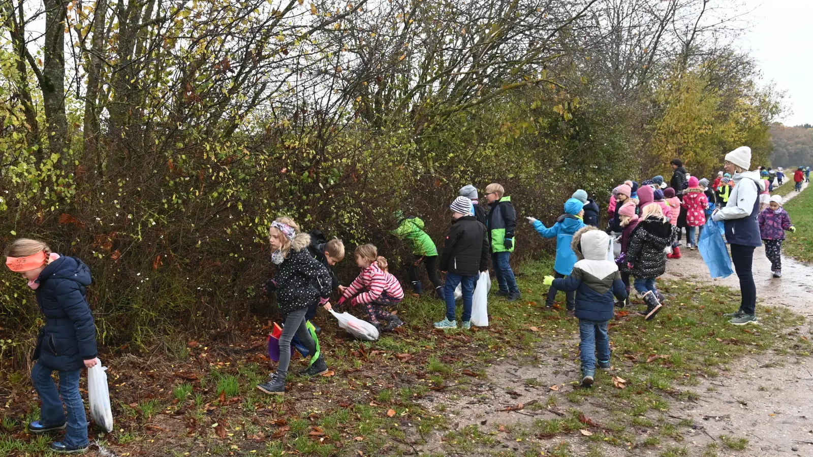 Rund 60 Kinder der Poppenrichter Grundschule beteiligen sich an der Rama-dama-Aktion. Sie ziehen mit Plastiktüten und Handschuhen „bewaffnet“ am Sportplatz entlang, um gedankenlos weggeworfenen Müll einzusammeln. (Bild: gf)