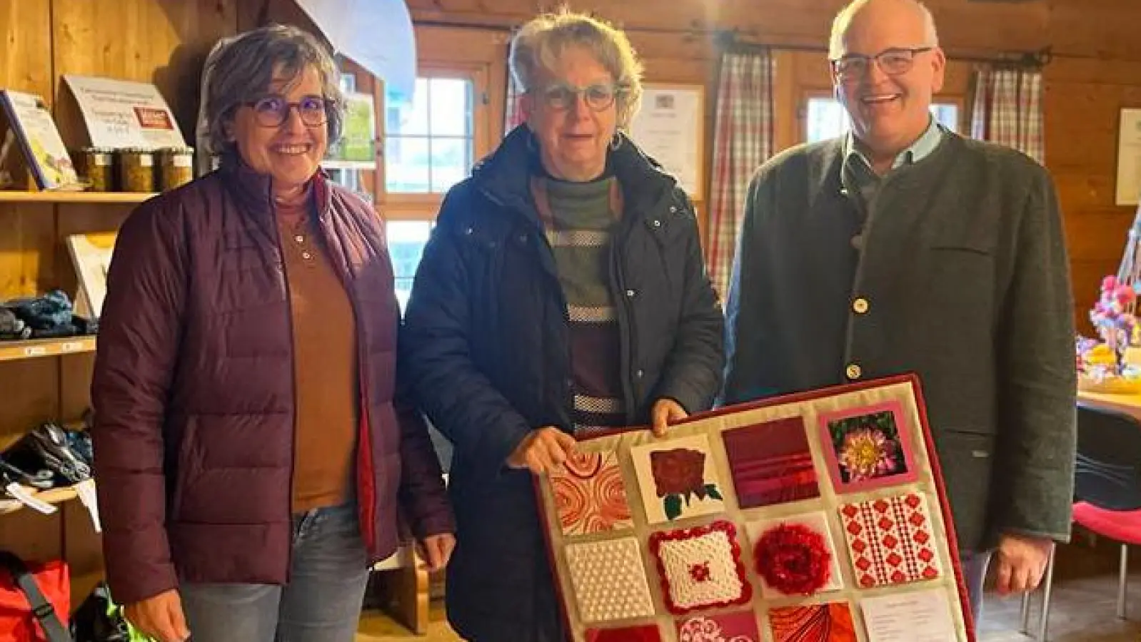 Beate Ott (links) und Monika Galbrecht vom Kreativtreff überreichten ein in der Runde angefertigtes Kunstwerk an Bürgermeister Klaus Meyer. (Bild: Ursula Stingl/exb)