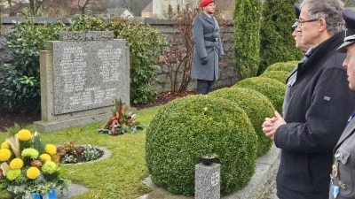 Am Ehrenmal legt Bürgermeister Franz Grabinger zusammen mit Mitgliedern der SKK-Auerbachtal eine Blumenschale zum Gedenken nieder. (Bild: ga)