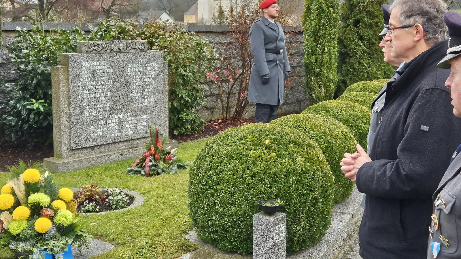Am Ehrenmal legt Bürgermeister Franz Grabinger zusammen mit Mitgliedern der SKK-Auerbachtal eine Blumenschale zum Gedenken nieder. (Bild: ga)