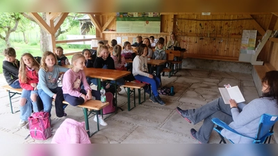 Im Pavillon des Kreislehrgartens versammelten sich die Kinder der Grundschulklasse 3a und lauschten dem Vortrag von Kathrin Plouschka aus dem Buch „Im Zeichen der Zauberkugel“.  (Bild: Fred Lehner)