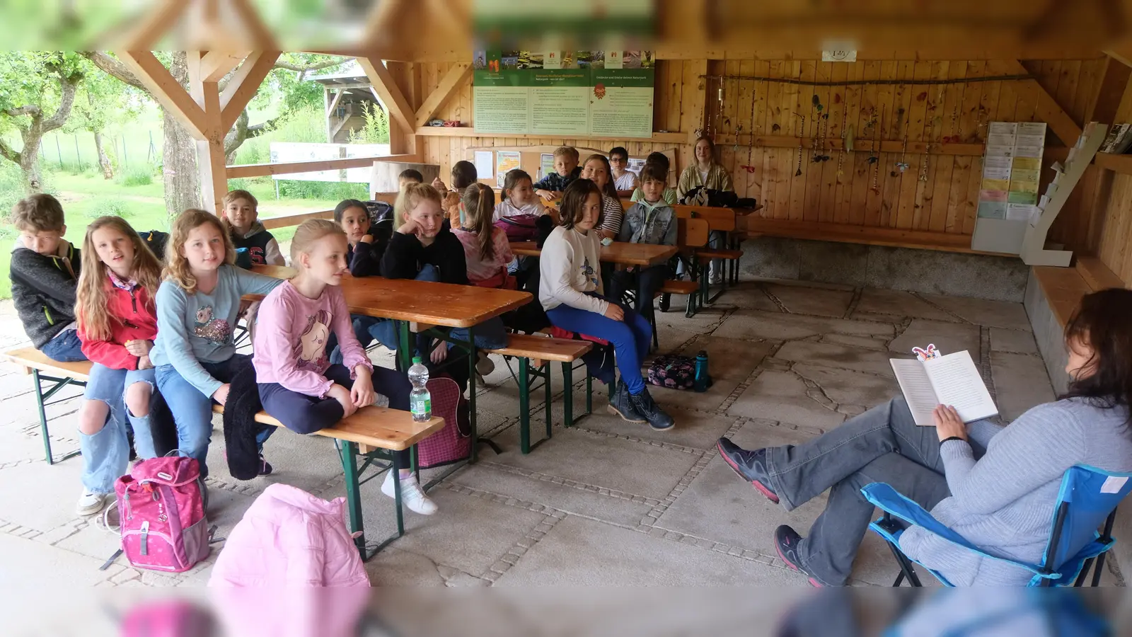 Im Pavillon des Kreislehrgartens versammelten sich die Kinder der Grundschulklasse 3a und lauschten dem Vortrag von Kathrin Plouschka aus dem Buch „Im Zeichen der Zauberkugel“.  (Bild: Fred Lehner)