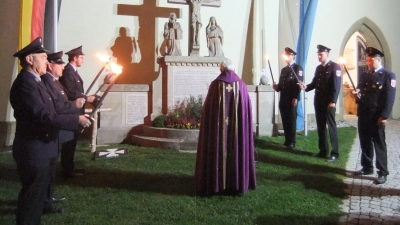 Feuerwehr sowie die Pfarrei von Pittersberg, zusammen mit der Gemeinde von Ebermannsdorf, stehen am Pittersberger Kriegerdenkmal und gedenken im Gebete aller Kriegstoten von damals, wie auch heute. Der Kranz soll äußeres Zeichen der Verbundenheit sein. (Bild: Michael Götz )