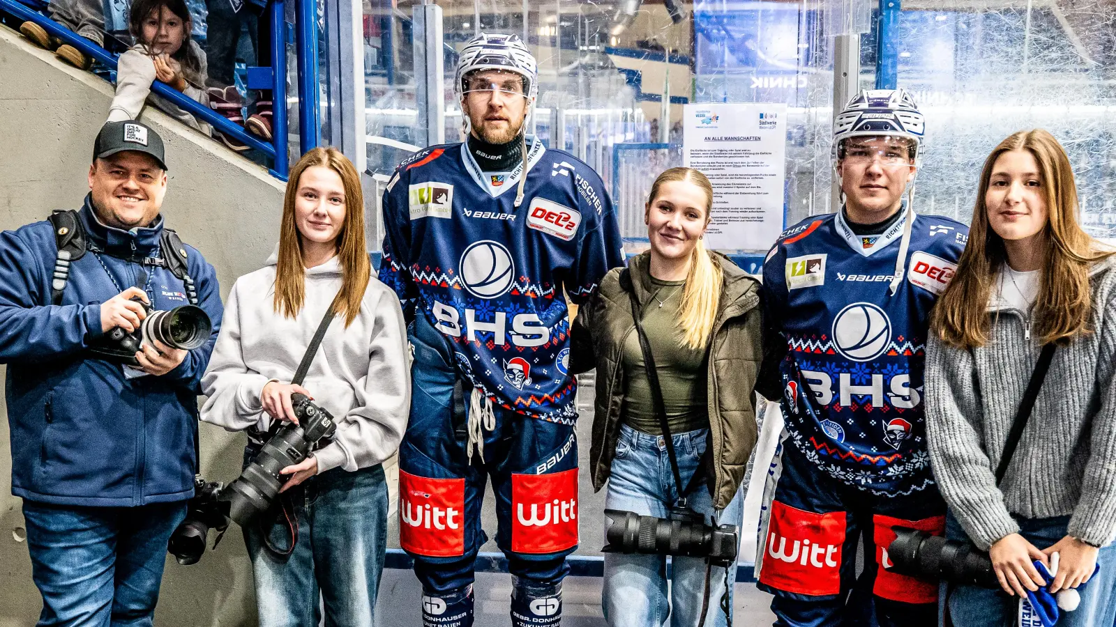 Erinnerungsfoto mit den Eishockeyspielern Luca Gläser (3.v.l.) und Marat Khaidarov (2.v.r.): Schülerinnen der Foto-AG mit ihrem Lehrer Tobias Neubert (li.). (Bild: Elke Englmaier)