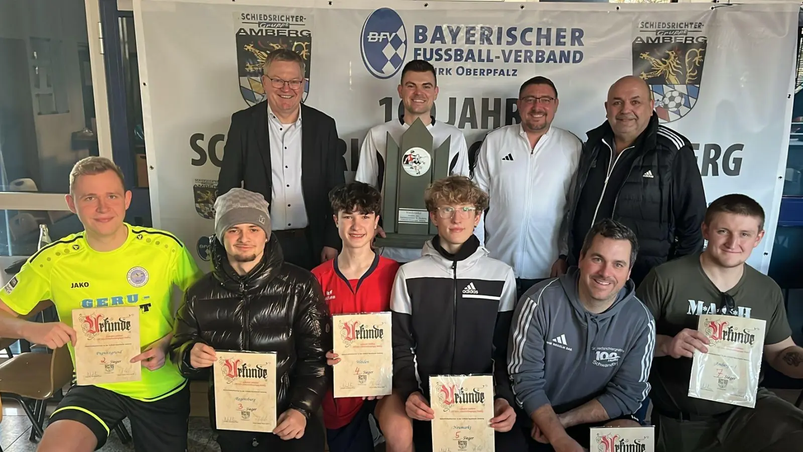 Anlässlich ihres 100-jährigen Jubiläums trafen sich sechs Schiedsrichtergruppen zum sportlichen Vergleich; Schirmherr OB Michael Cerny (1.v.l.) und Bezirksschiedsrichter-obmann Markus Weigert (3.v.l.) mit Amberg’s SR-Chef Thomas Gebele (3.v.l.) nahmen die Siegerehrung vor; den Wanderpokal nahm für Amberg-2 Jonas Kohn (2.v.l.) entgegen; auf den weiteren Plätzten folgten (kniend v.l.) Pegnitzgrund (2.), Regensburg (3.), Weiden (4.), Neumarkt (6.), Schwandorf (6.) und Amberg-1 (7.)  (Bild: Thomas Ehrnsperger)