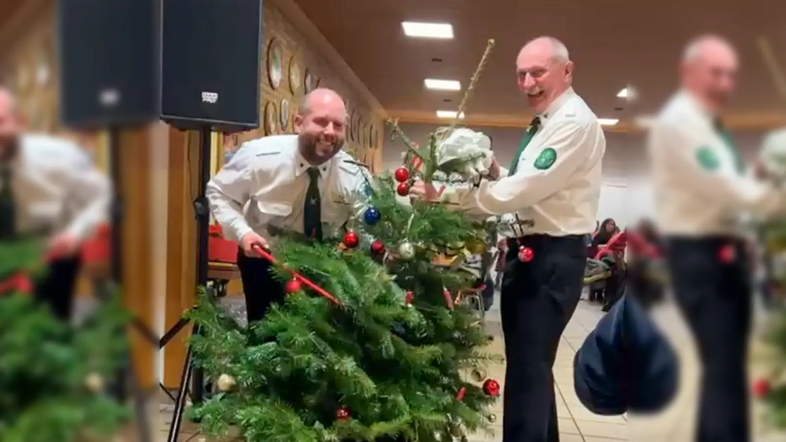 1. Schützenmeister Andreas Hammer (links) sowie der Schießleiter und zugleich Böllermeister Herbert Raß (rechts) haben da gegen Ende der Christbaumversteigerung beim Absägen des Gipfels schon gut lachen, denn der Abend war letztlich für die Bergschützen ein voller Erfolg! (Bild: Michael Götz)