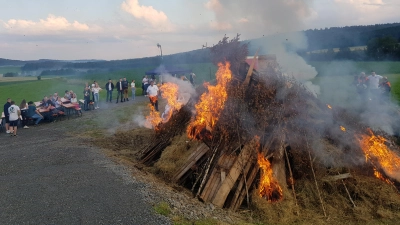 Die Landjugend Tröbes bleibt dem Brauchtum treu und entzündet das Johannisfeuer auf der Busl-Höhe über Tröbes, das Pfarrer Udo Klösel gesegnet hatte. (Bild: Peter Garreiss)