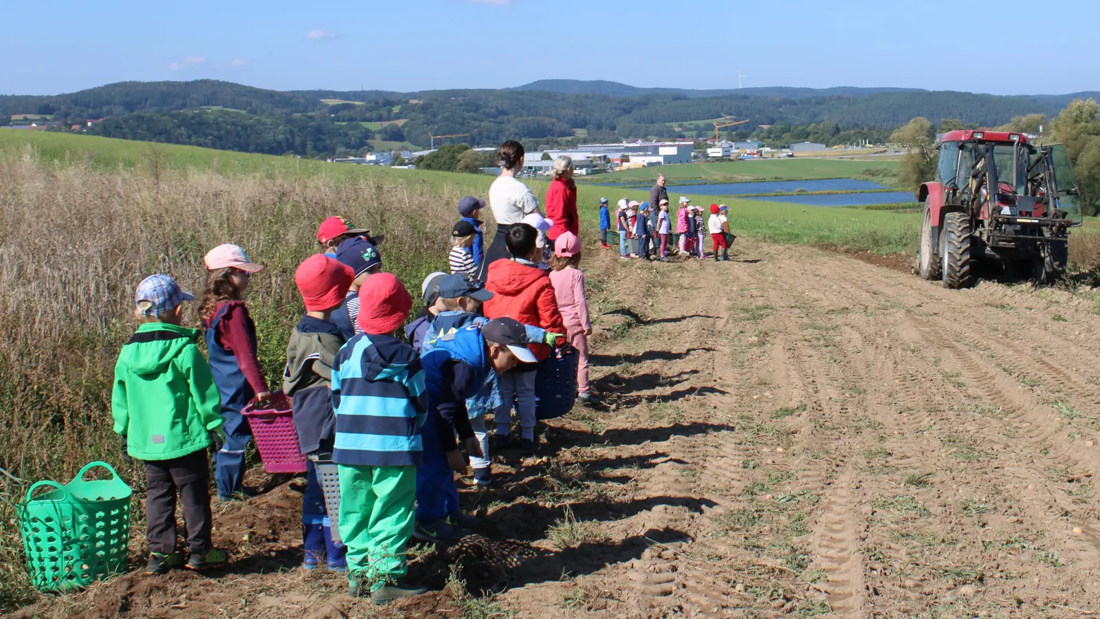 Die Kinder des Kindergarten St. Marien bestaunen den großen Bulldog auf dem Kartoffelacker.  (Bild: Julia Gschrey)