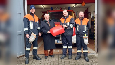 Vorsitzender Michael Weiß, Ehrenmitglied Ulrich Schmid, Kommandant Benjamin Weiß und Zweiter Vorsitzender Philipp Meier (von links) mit dem neuen Schwimmsauger. (Bild: Johannes Winkler/FF Lintach/exb)