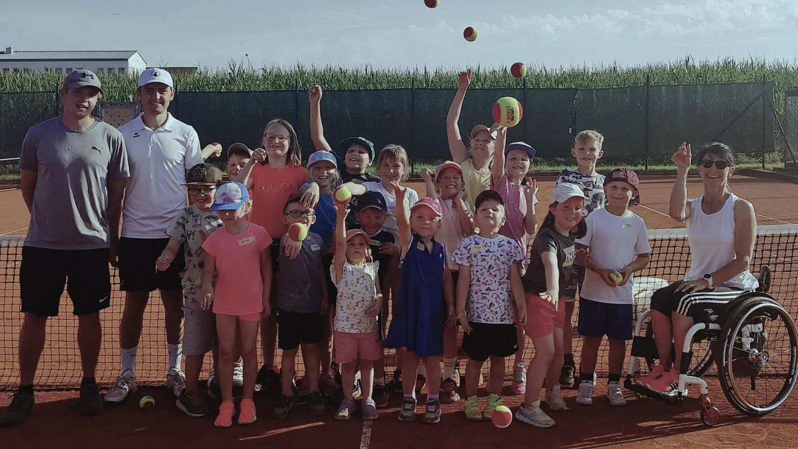 Das Bild zeigt die glücklichen 21 Kinder des Tennis-Ferienprogramms unter Anleitung von Hannes Kern (links), Luis Kern (zweiter von links) und Doris Scharnagl-Lindinger (rechts).<br><br> (Bild: Heiko Faltenbacher)