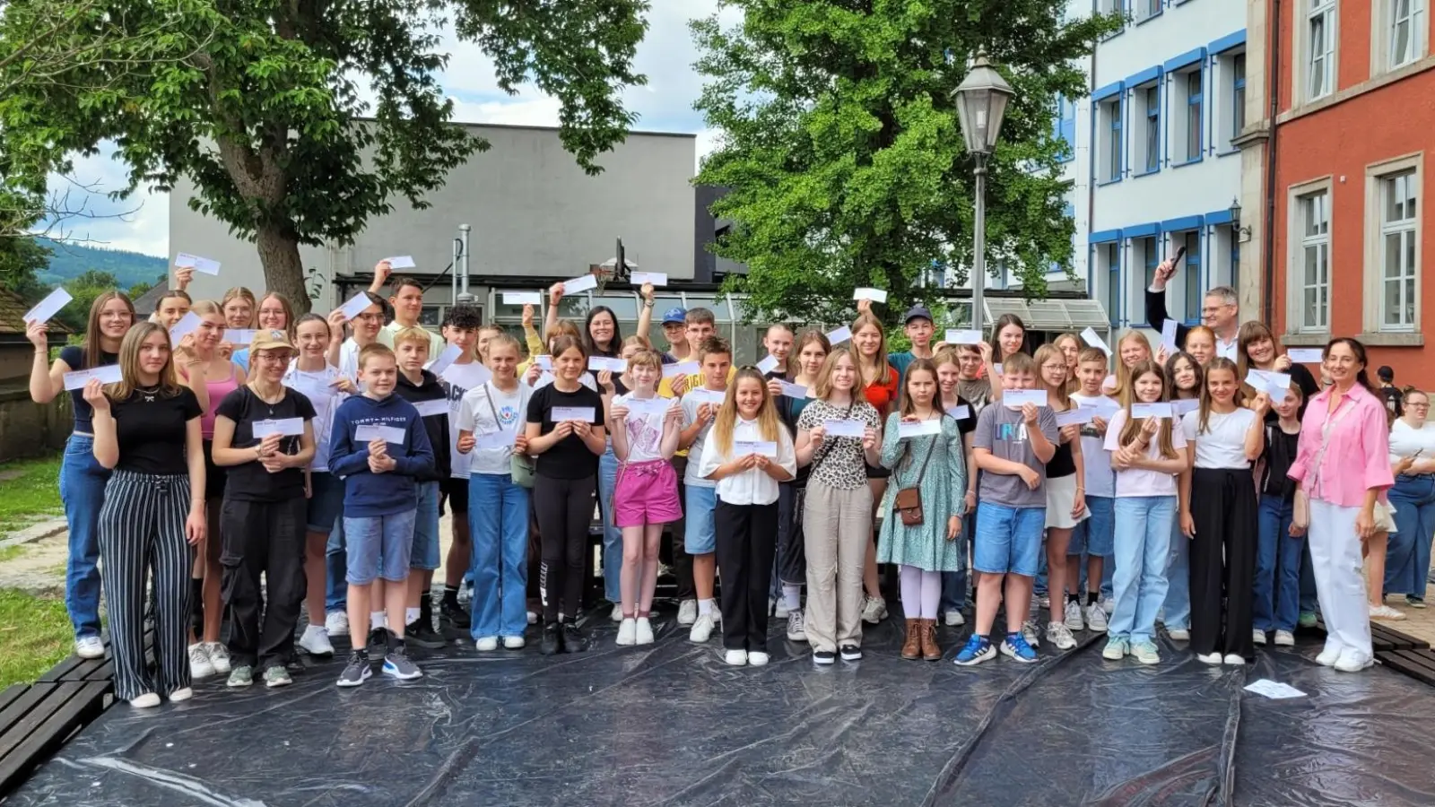 Die Besten des Schuljahres am Wunsiedler Gymnasium freuen sich über ihre Ehrung und einen Wertgutschein, den ihnen der stellvertretende Schulleiter Oliver Ziegler (hinten rechts) und die Elternbeiratsvorsitzende Silvia Merkl (vorne rechts) überreicht hatten. (Bild: Markus Wagner)