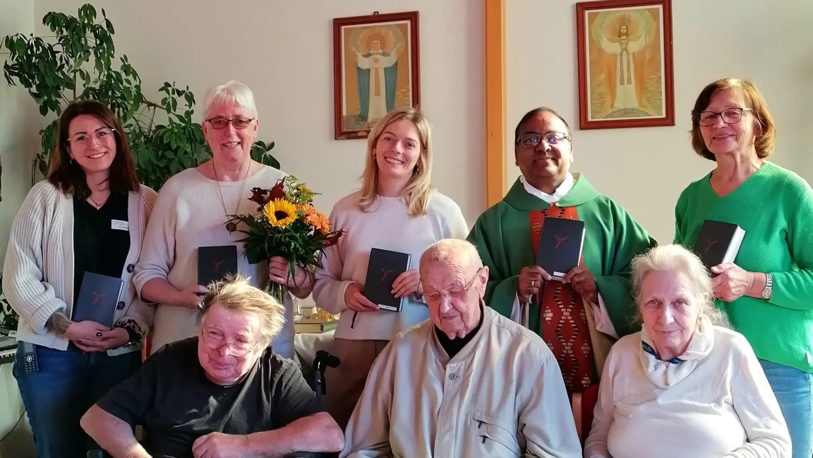 Für die Gottesdienste im Haus der Betreuung und Pflege in Schlicht gab es vom Schnäppchenladen neue Gebetbücher. Mit den Heimbewohnern freuten sich (hinten von links) Elisabeth Willing, Veronika Pröls, Theresa Kerschbaum, Stadtpfarrer Hrudaya Madanu und Lektorin Resi Regler.  (Bild: Rosi Hasenstab)