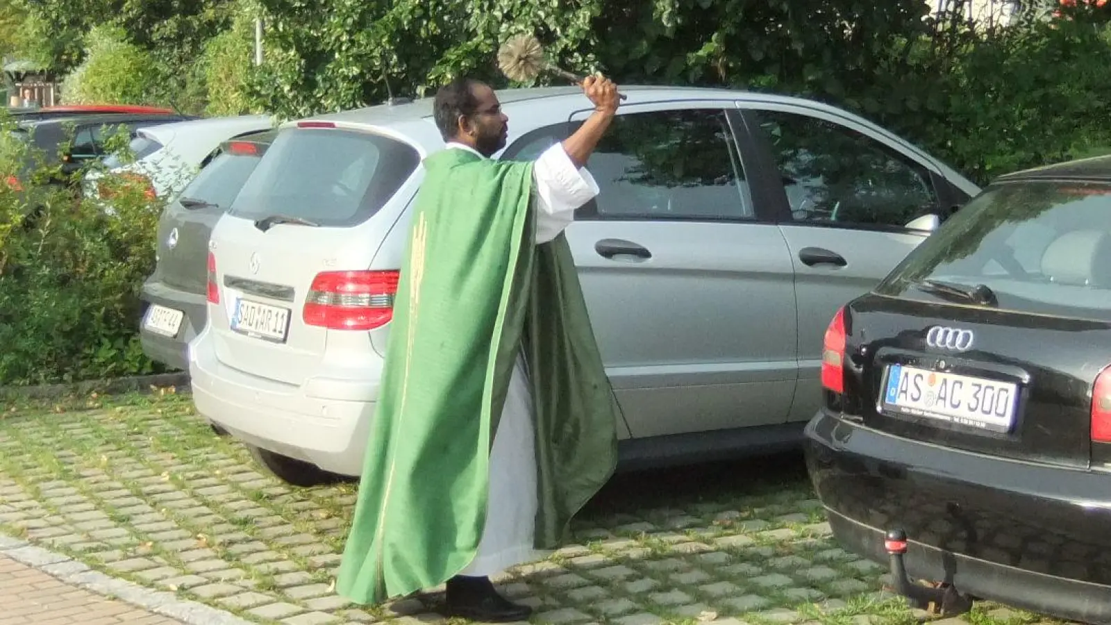 Seelsorger Sagai besprengt die Fahrzeuge mit Weihwasser im gläubigen Vertrauen darauf: An Gottes Segen ist alles gelegen. (Bild: gm)