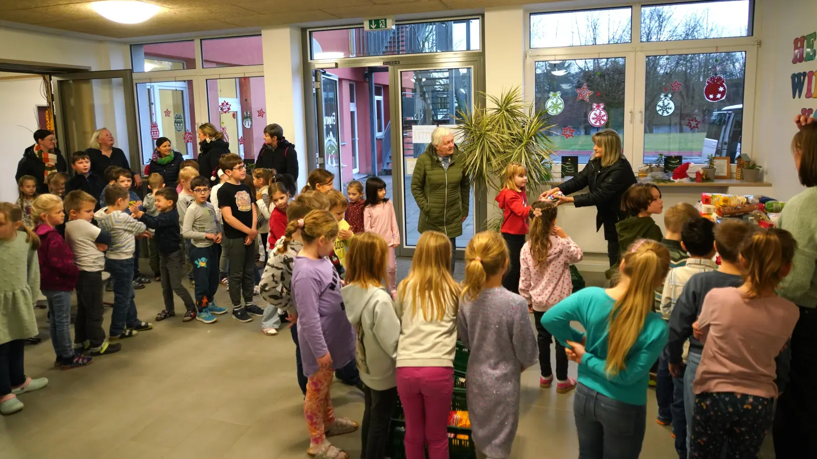 Gemeinsam mit den beiden Vohenstraußer Tafelmitarbeiterinnen Luise Schmid-Huber (rechts) und Hedwig Reger (Mitte) laden die Waldthurner Schulkinder die Lebensmittel zum Abtransport in Kisten. (Bild: Franz Völkl )