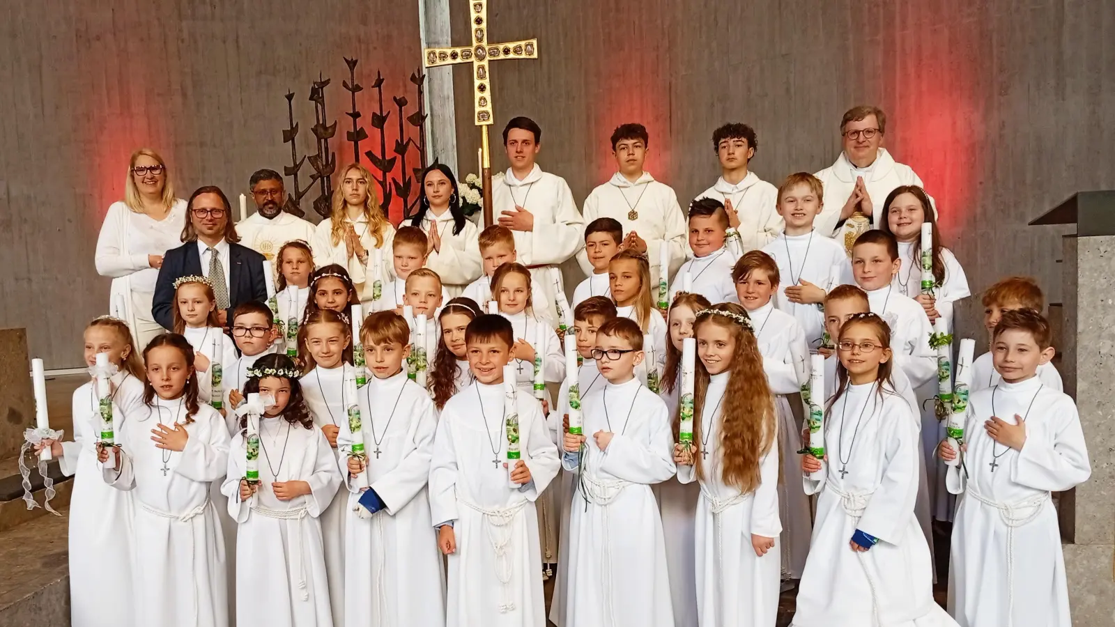 Das Bild zeigt die Kommunionkinder mit (hintere Reihe von links) Yvonne Landefeld, Sebastian Stejskal, Pater Jo, die Ministranten und Stadtpfarrer Bernd Philipp.  (Bild: Oswald Zintl)