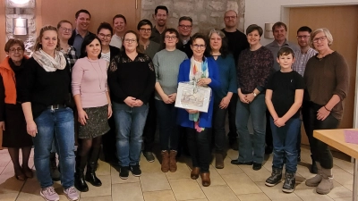 Doris Etzold (mit Aquarell) mit den Mitgliedern der Kirchenverwaltung und Kolleginnen aus dem „Haus der Kinder St. Konrad” bei ihrer Verabschiedung im Rahmen des Neujahrempfangs der Pfarrei St. Konrad.  (Bild: Tobias Neudecker)