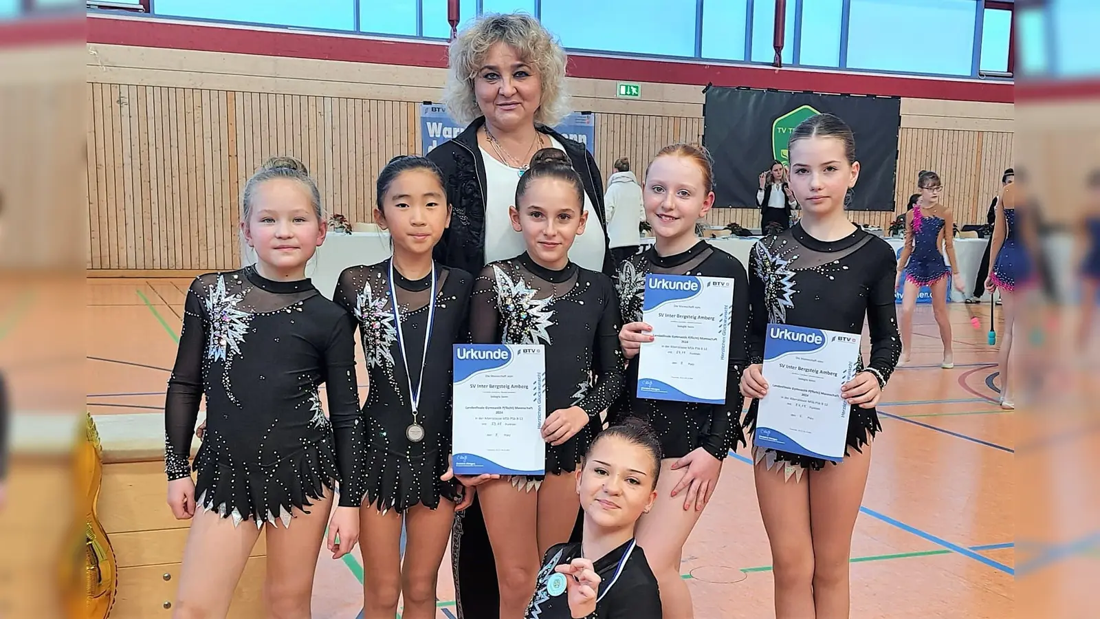 Ein herausragendes Ergebnis erzielten die jungen Sportlerinnen des SV Inter Bergsteig, hier mit ihrer Trainerin Olga Tesmann, beim Landesfinale der Rhythmischen Sportgymnastik in Traunstein. (Bild: Nicole Binner)