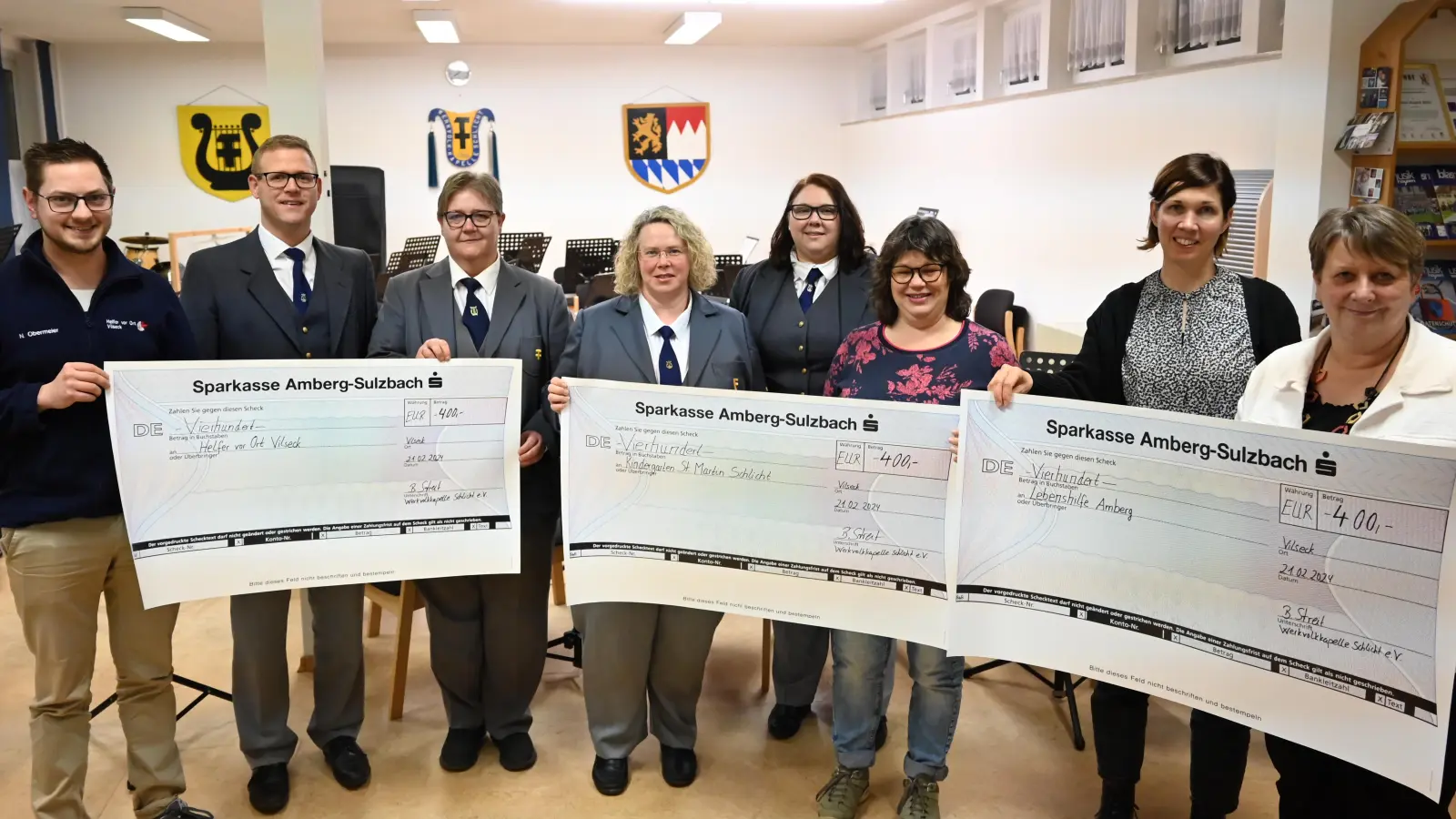 Die Werkvolkkapelle (WVK) Schlicht übergibt Spenden aus dem Erlös ihres Adventskonzerts (von links): Niklas Obermeier (Helfer vor Ort), Andreas Kredler (WVK), Anja Bauer (WVK), Barbara Streit (WVK), Sabine Kredler (WVK), Sonja Schnellinger (Kindergarten St. Martin Schlicht), Melanie Dietrich (Lebenshilfe AS) und Katrin Panek (Lebenshilfe AS). (Bild: sak)