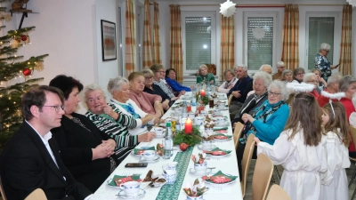 Festlich gedeckt war die lange Tafel im Rotkreuzheim bei der letzten Seniorenstube in diesem Jahr. Die Weihnachtsfeier nahm Bereitschaftsleiter Helmut Zeitler zum Anlass, Marianne Richter (Fünfte von links) für 60-jährige Treue zum BRK zu ehren. (Bild: Lothar Riedl/exb)