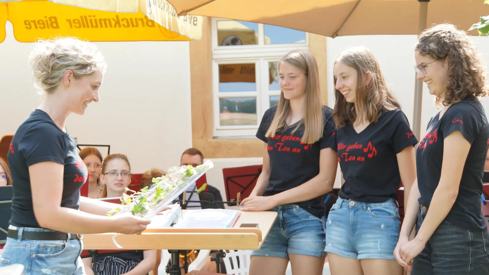 Die vier Dirigentinnen des Konzerts (v..l.): Angelika Schöpf überreicht Maria Dotzler, Paula Dotzler und Carolin Ruppert ihre Dirigentenstäbe (Bild: Markus Schlotmann)