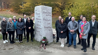 SPD-Landesvorsitzende Ronja Enders mit einer Abordnung der Flossenbürger SPD am „Stein des Anstoßes“ zum Gedenken an die verstorbenen Mitglieder. (Bild: Andrea Egner)