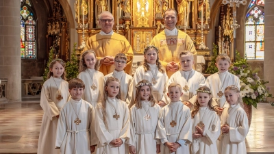 12 Kinder feiern ihre Erstkommunion mit Pfarrer Thomas Helm und Diakon Richard Sellmeyer in St. Martin Amberg. (Bild: Michael Golinski)