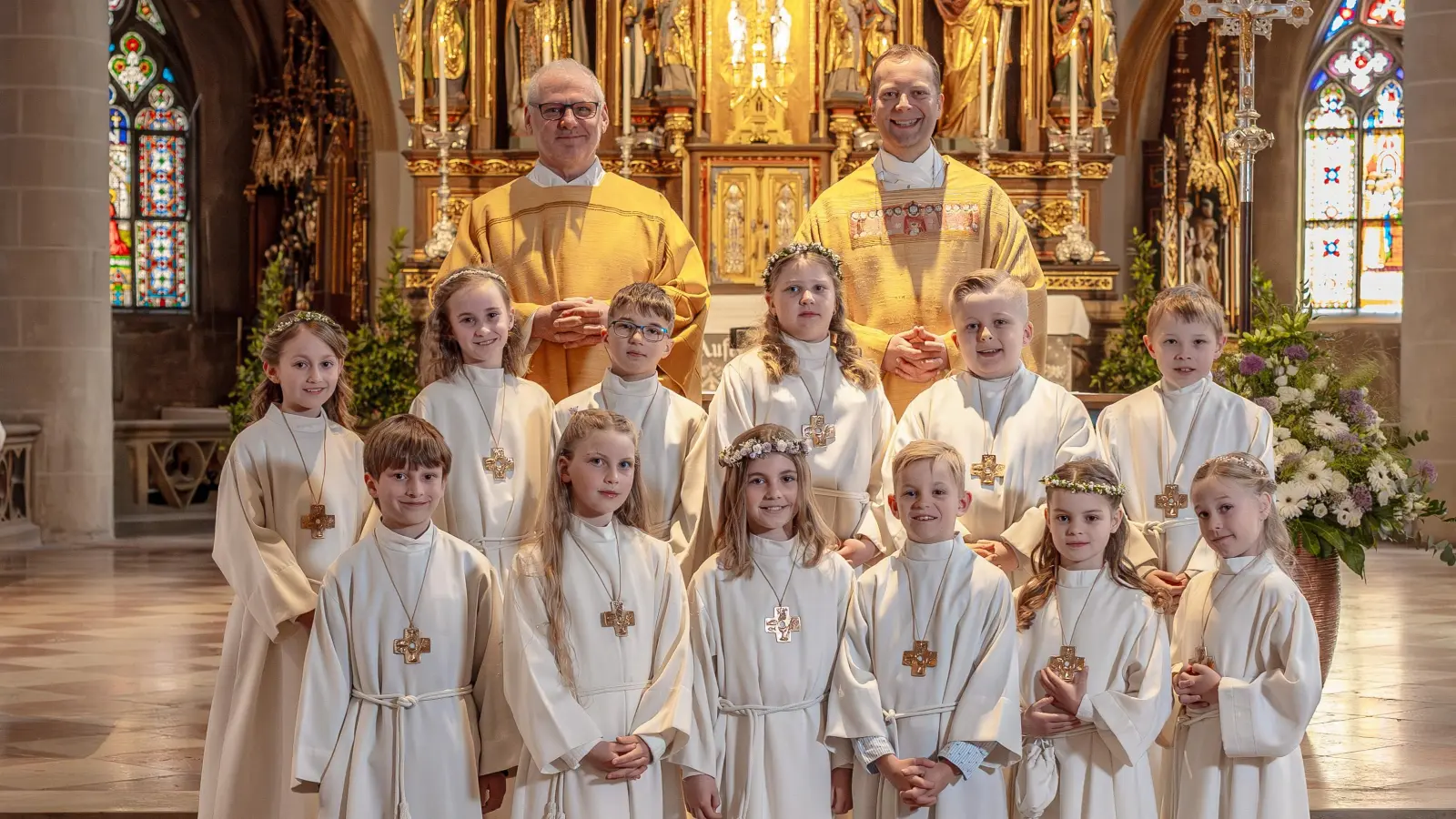 12 Kinder feiern ihre Erstkommunion mit Pfarrer Thomas Helm und Diakon Richard Sellmeyer in St. Martin Amberg. (Bild: Michael Golinski)