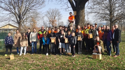 Die Schülerinnen und Schüler der Mittelschule gemeinsam mit Lehrkräften und Vertretern der örtlichen Berufsschule, Erstem Bürgermeister Martin Birner und Vorsitzenden des Arbeitskreises Biodiversität Alexander Trinkmann beim Montieren der Nistkäste im Stadtpark.<br><br>  (Bild: Johanna Auburger. )