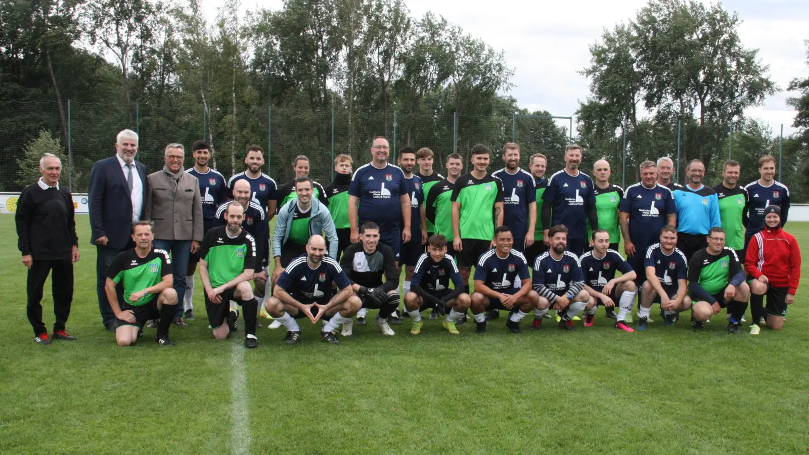 Die Fußballmannschaften Lauf a. d. Pegnitz (in schwarz) und Tirschenreuth (in grün, blau und rot) mit den Bürgermeistern Franz Stahl (Vierter von links) und Thomas Lang (Zweiter von links).<br> (Bild: Norbert Neid)