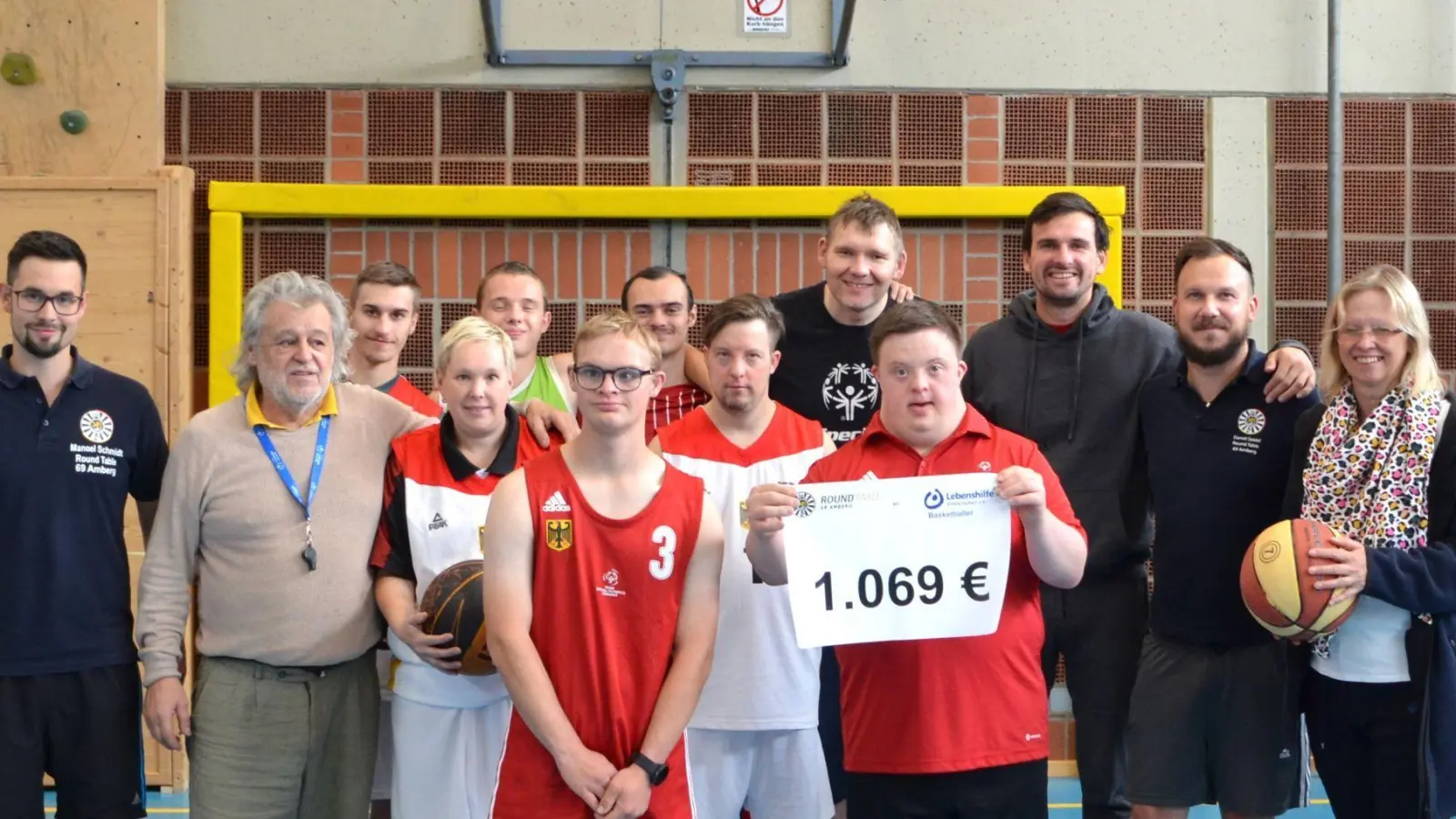 Das Basketball-Team der Lebenshilfe freute sich über die Spende von Round Table 69 Amberg. Den Scheck nahmen Coach Engelbert Ludwig Weidel (Zweiter von links), die erste Mannschaft und Verwaltungsleiterin Michaela Winklmeier (rechts) von Manoel Schmidt (links) sowie Michael Thiel und Daniel Seidel (Dritter und Zweiter von rechts) entgegen. (Bild: Michaela Winklmeier/exb)