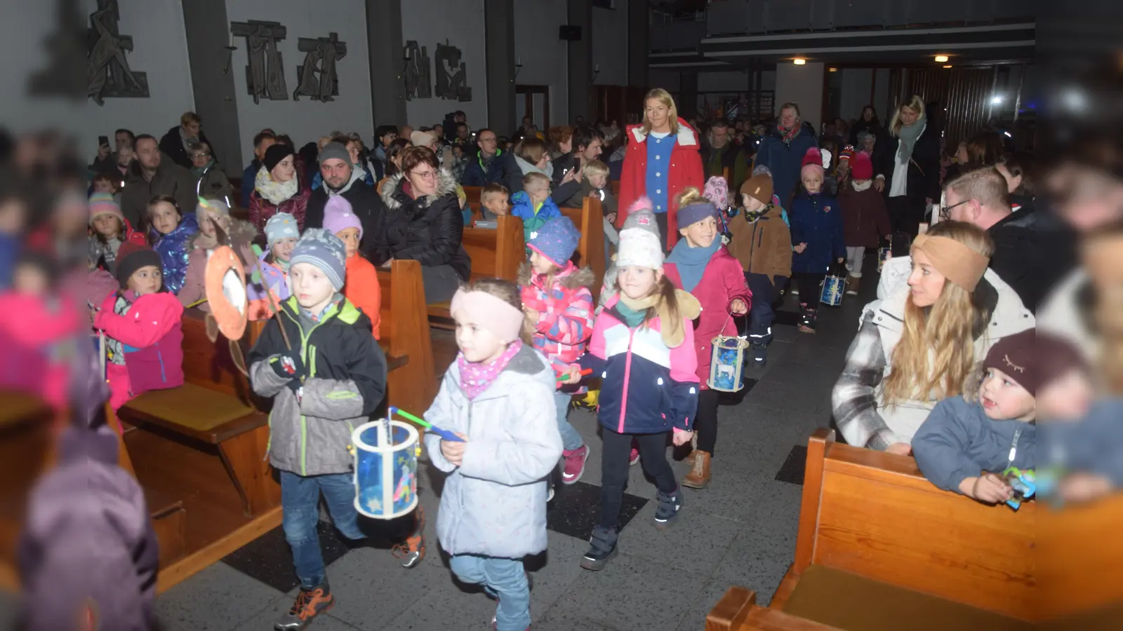 Singend mit ihren Laternen ziehen die Kinder zur Martinsfeier in die Kirche ein. (Bild: fz)