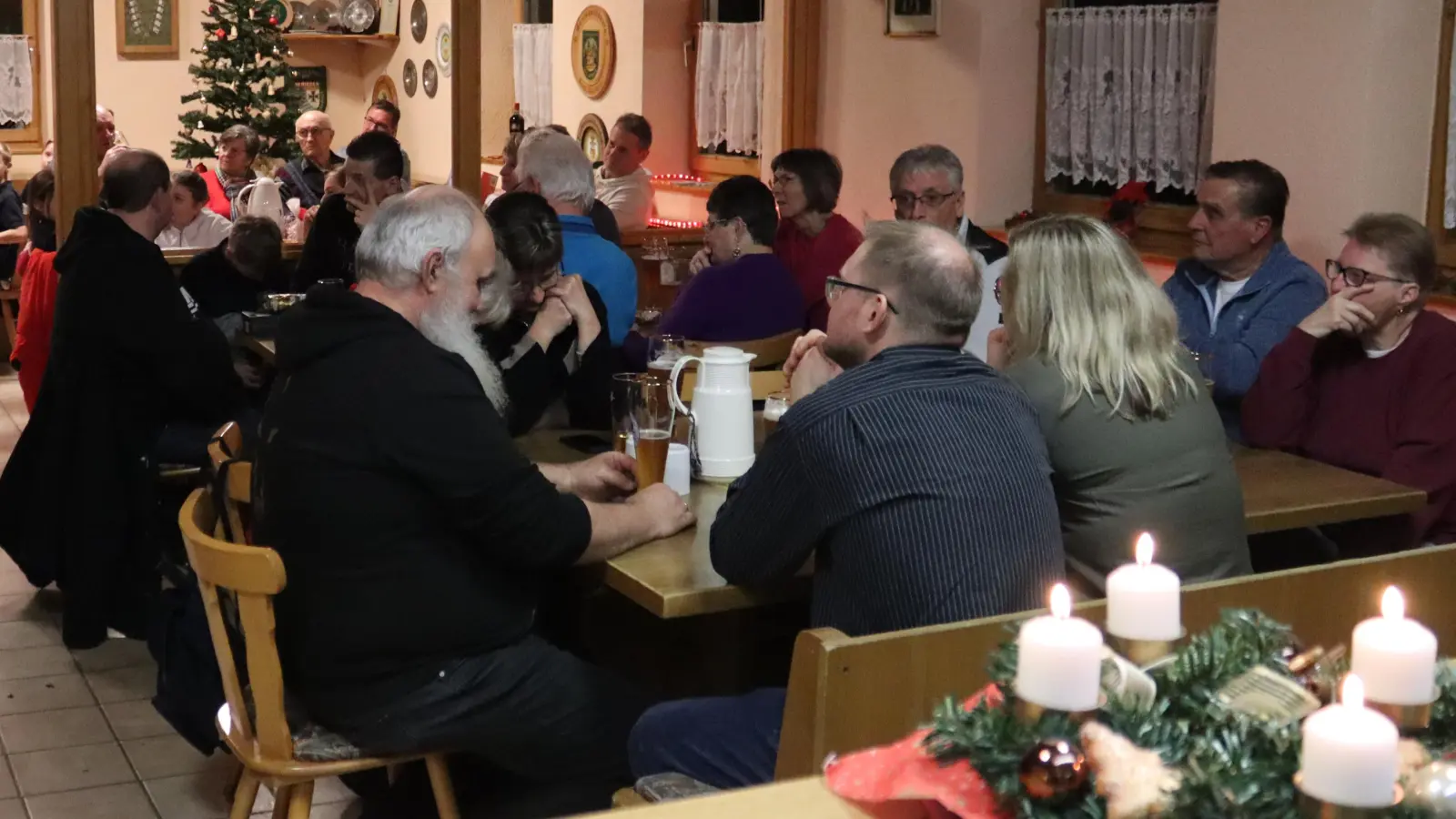 Weihnachtliche Stimmung bei den Riedener Vilstalschützen zur Weihnachtsfeier. Schießleiter Manfred Hiermann (stehend, links) gibt die Ergebnisse des Weihnachtsschießens bekannt. (Bild: Michael Rabenhofer)