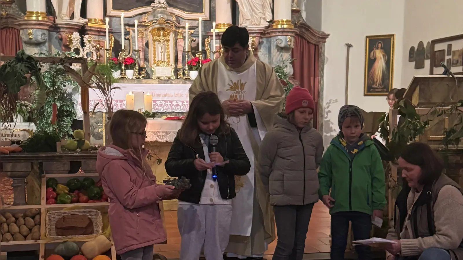 Die Kinder stellen Trauben und Brot vor und bringen diese zur Gabenbereitung Pater Ivan. (Bild: Nicole Schusser-Schindler)