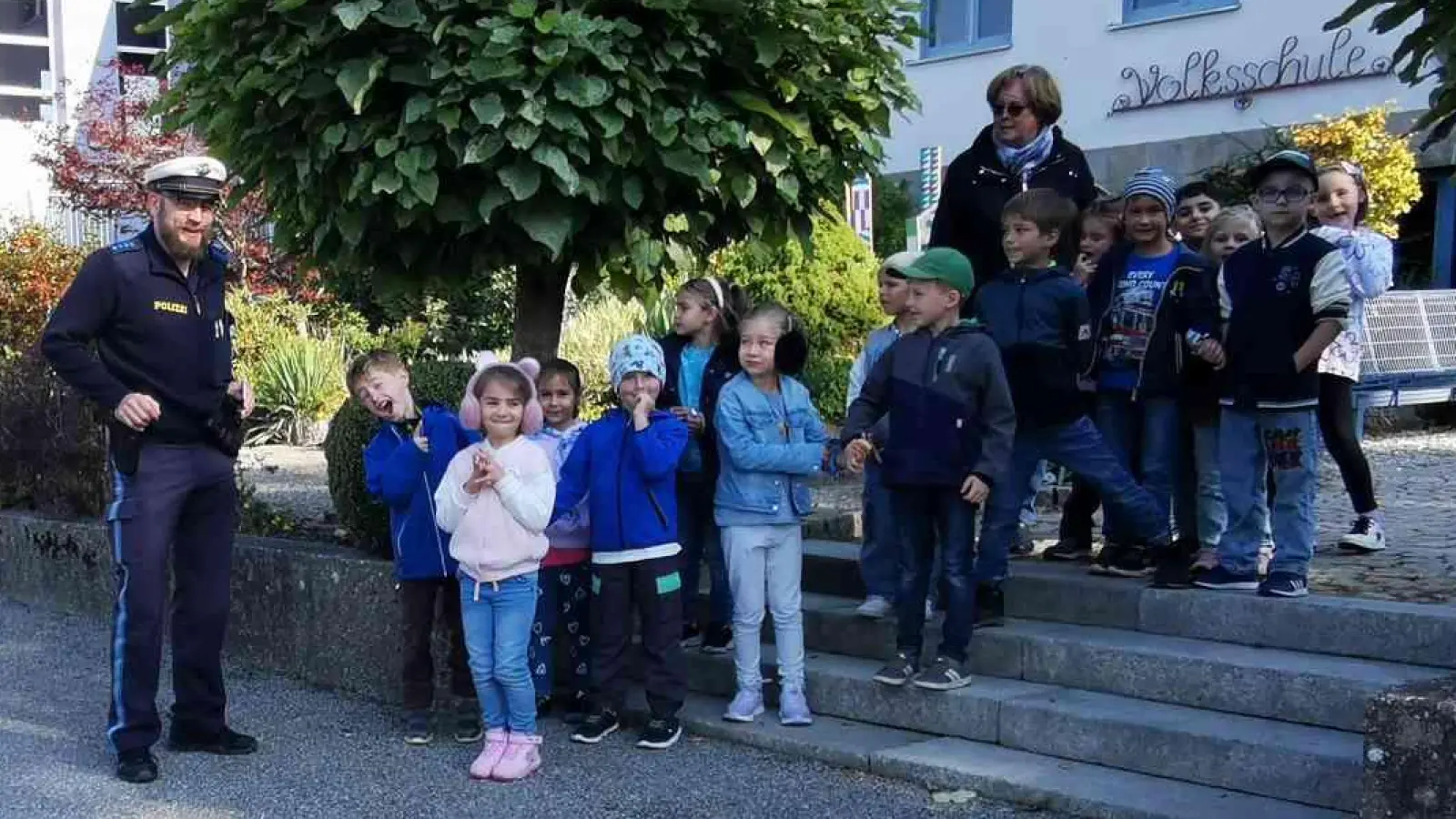 Verkehrserzieher Wolfgang Piehler übt im Beisein von Klassleiterin Ramona Mensch mit den Kindern das Überqueren der Straße. (Bild: Karl Ziegler)