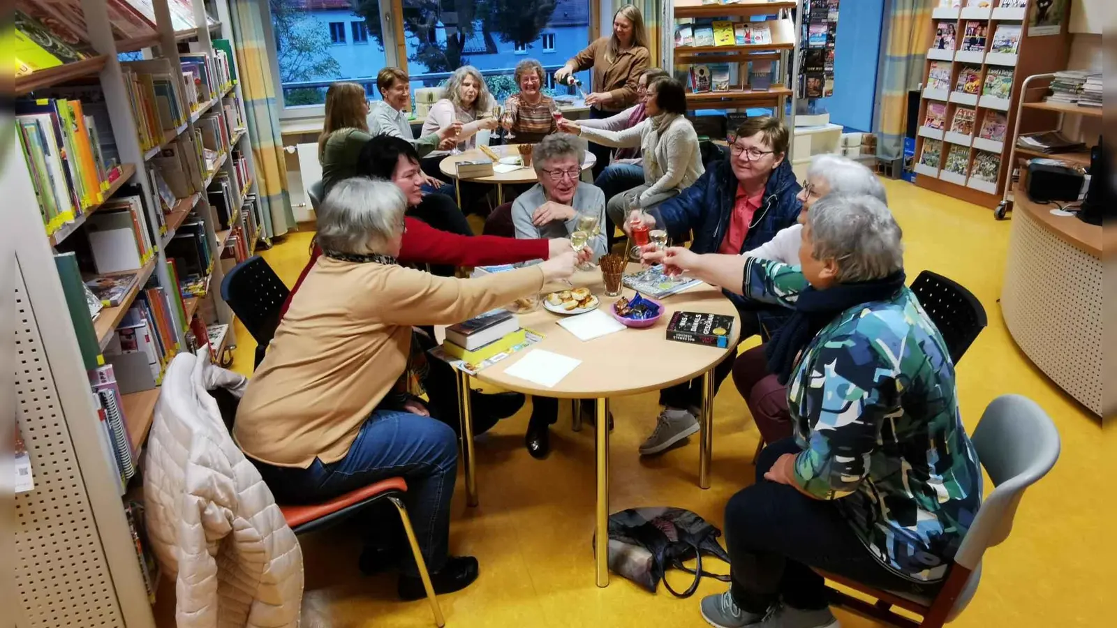 Das Büchereiteam in Eslarn um Melanie Frank (stehend hinten) versorgt die Lesebegeisterten mit Sekt und Snacks. (Bild: gz)