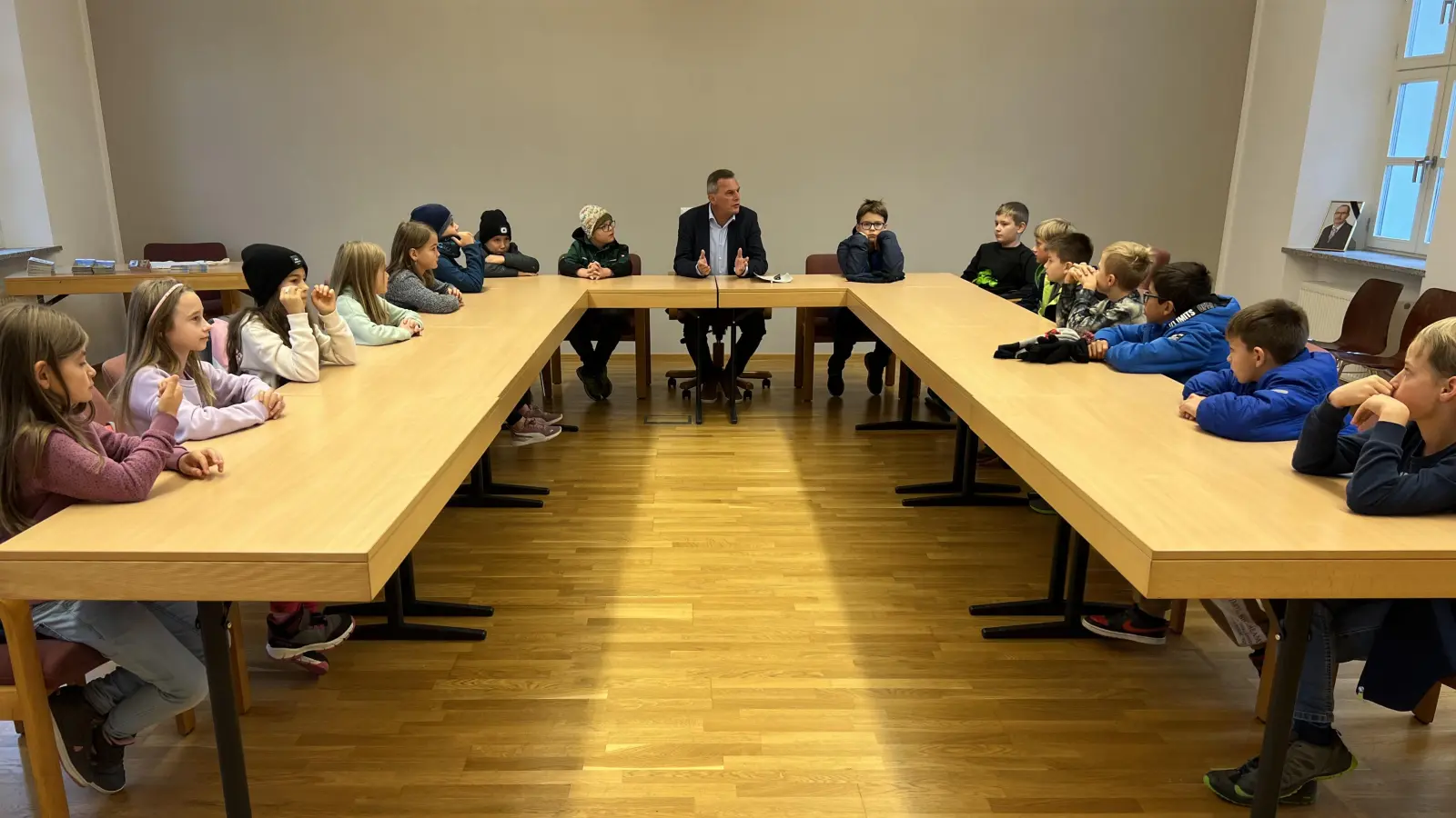 Auf den Plätzen der Gemeinderäte nehmen die Grundschüler Platz und stellen Bürgermeister Norbert Eckl ihre Fragen.  (Bild: Grundschule Teunz/exb)