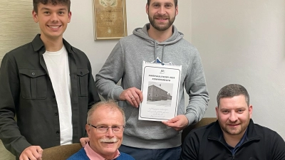 JU-Ortsvorsitzender Benedikt Wenisch, Marius Ulrich (stehend, von links) und Philipp Schwan (sitzend, rechts) überreichten die ersten Exemplare des JU-Kalenders 2024 an Bürgermeister Max Bindl.<br> (Bild: JU Konnersreuth/exb)