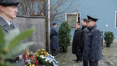 Michael Liedtke, Vorsitzender der Soldaten- und Reservistenkameradschaft Oberwildenau, Bürgermeister Sebastian Hartl und Marktgemeinderat Gerhard Kres, verharren nach der Kranzniederlegung in stillem Gedenken vor dem Kriegerdenkmal  (Bild: bey)