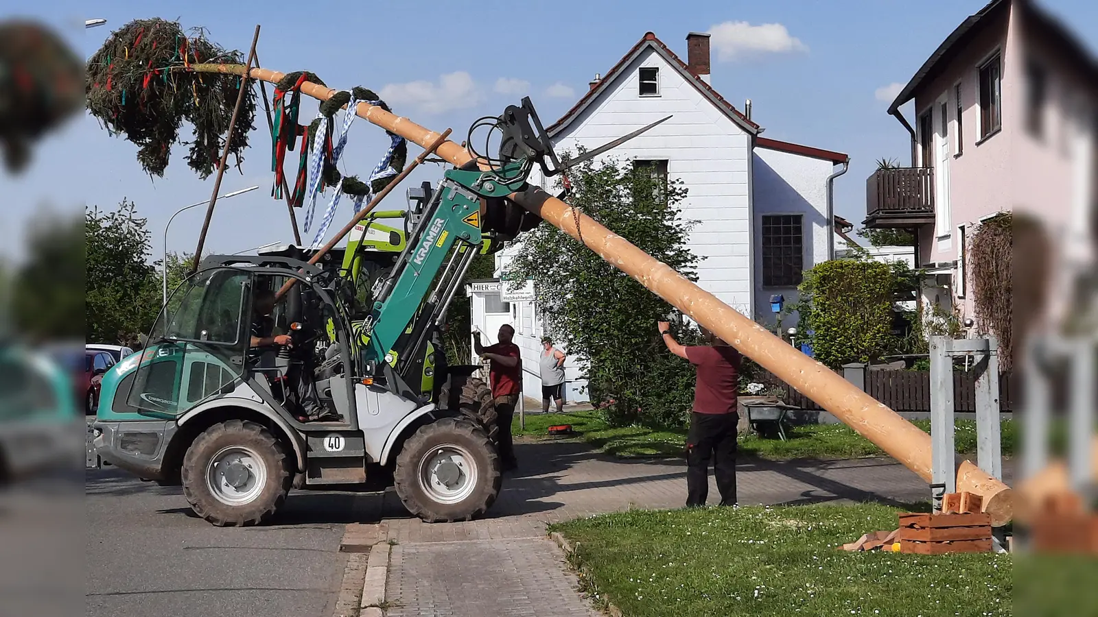 Mit einem Traktor sichern Mitglieder den Maibaum, mit acht Schwalben hoben Männer den Baum in die Höhe, der nun zum 60-jährigen Jubiläum auf der Dorfwiese stehen bleibt. (Bild: R. Kreuzer)