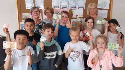 OGTS-Leiterin Maria Bernhard (hinten rechts) und Kinder der Offenen Ganztagsschule freuen sich über die Spende, die Gisela Westiner (hinten links) und Marie Luise Pfeifer (daneben) überreichen. (Bild: Gabriela Amann)