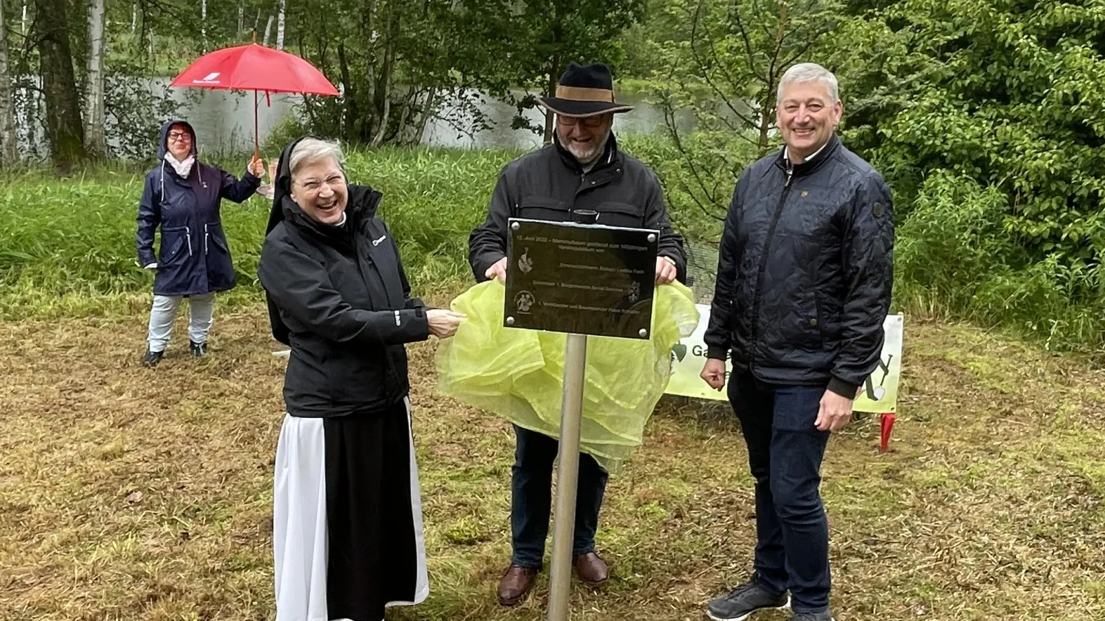 Äbtissin Laetitia Fech, Klaus Schuster vom Obst- und Gartenbauverein sowie Markus Scharnagel als Vertreter des Bürgermeisters enthüllten das Schild. (Bild: Klaus Schuster/exb)