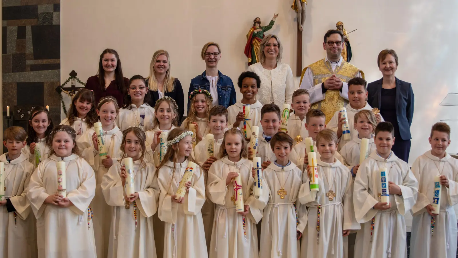 22 Kinder treten erstmals an den Tisch des Herrn (hinten, von links): Lehramtsanwärterin Vicky Steindl, die Klassleiterinnen Marie Nietschmann und Simone Koch, Schulleiterin Janina Schmidt, Pfarrer Dominik Mitterer und Gemeindereferentin Regina Probst. (Bild: Ludwig Schneider/exb)