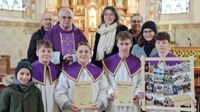 Vorne Sinan Birol (Kommunionkind), Lukas und Lina Schafbauer mit Urkunden und Benjamin und Robin Götz, dahinter von links Mesner Günther Reger, Pfarrer Eugen Wismeth, Lektorin Sophia Ebner, Kirchenpfleger Michael Brandl und Ministrantenbetreuerin Verena Kraus. (Bild: Annemarie Mösbauer)