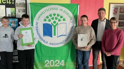 Stolz zeigen Schüler der 6. Klassen die Urkunde der Umweltschule. Mit ihnen freuen sich StRin (MS) Felicitas Berger und Schulleiter Florian Fuchs  (Bild: Katharina Kraus)