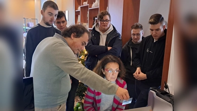 Gabrielle Neumüller-Wölfl (sitzend), die Schatzmeisterin der Mitterteicher Tafel, mit am Projekt beteiligten Schülern. (Bild: Hartmut Seidler)
