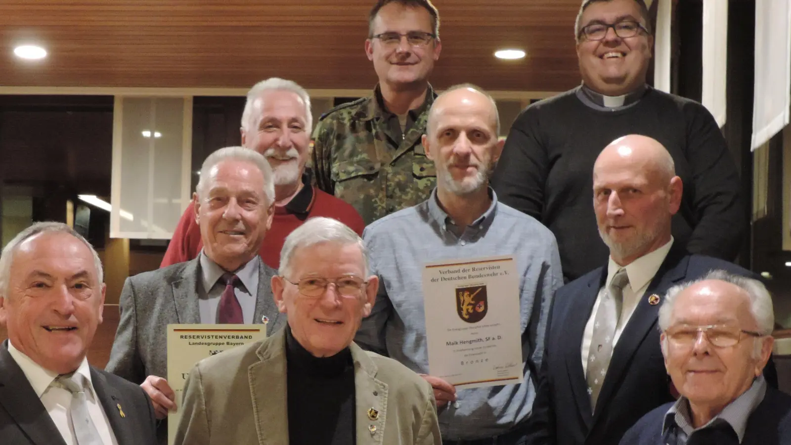 Oberstleutnant Klaus-Peter Lackmann und Militärpfarrer Christoph Wilczak (oben von links) mit den Geehrten: Jörg Pischke, Bernd Hummel, Maik Hengmith und Vorsitzender Andreas Schulz (Mitte von links) sowie Werner Gebhard, Manfred Hörmannsdorfer und Alfred Daucher (vorne von links). (Bild: Meyfeld, RK Amberg/exb)