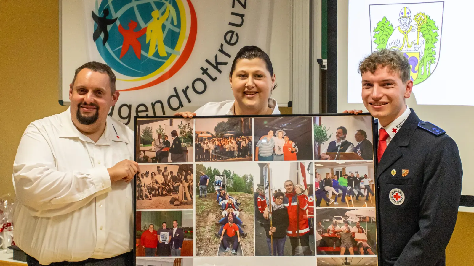 Das Geschenk der Osterhofener Jugendrotkreuzler war eine Bildercollage aus 30 Jahren Partnerschaft. Im Bild von links der stellv. Leiter der Jugendarbeit im BRK Kreisverband Thomas Salomon, JRK-Leiterin Katharina Fröhler aus Osterhofen und JRK-Leiter Florian Müller aus Waldsassen. (Bild: Karsten Friedrich)