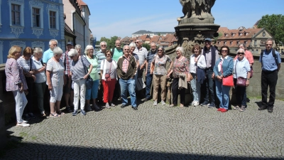 Eine Pause machte die Seniorennetz-Reisegruppe auf der Alten Rathaus-Brücke vor der Statue der Königin Kunigunde. (Bild: Werner Nickel)